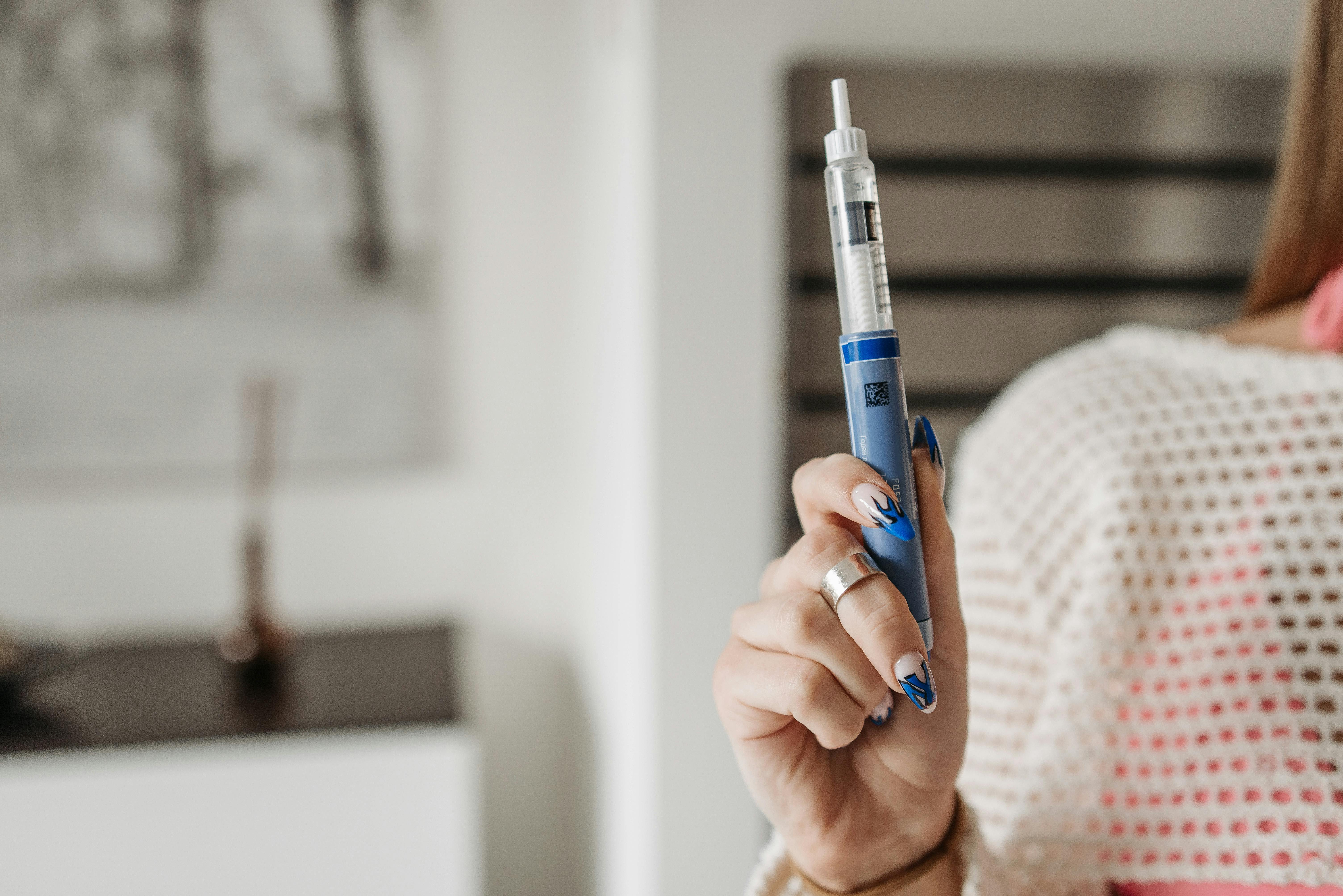 A hand holding a GLP-1 injection pen with the cap removed — Ozempic in Ontario 2026: ODB Coverage, Pharmacy Pricing and Online Providers